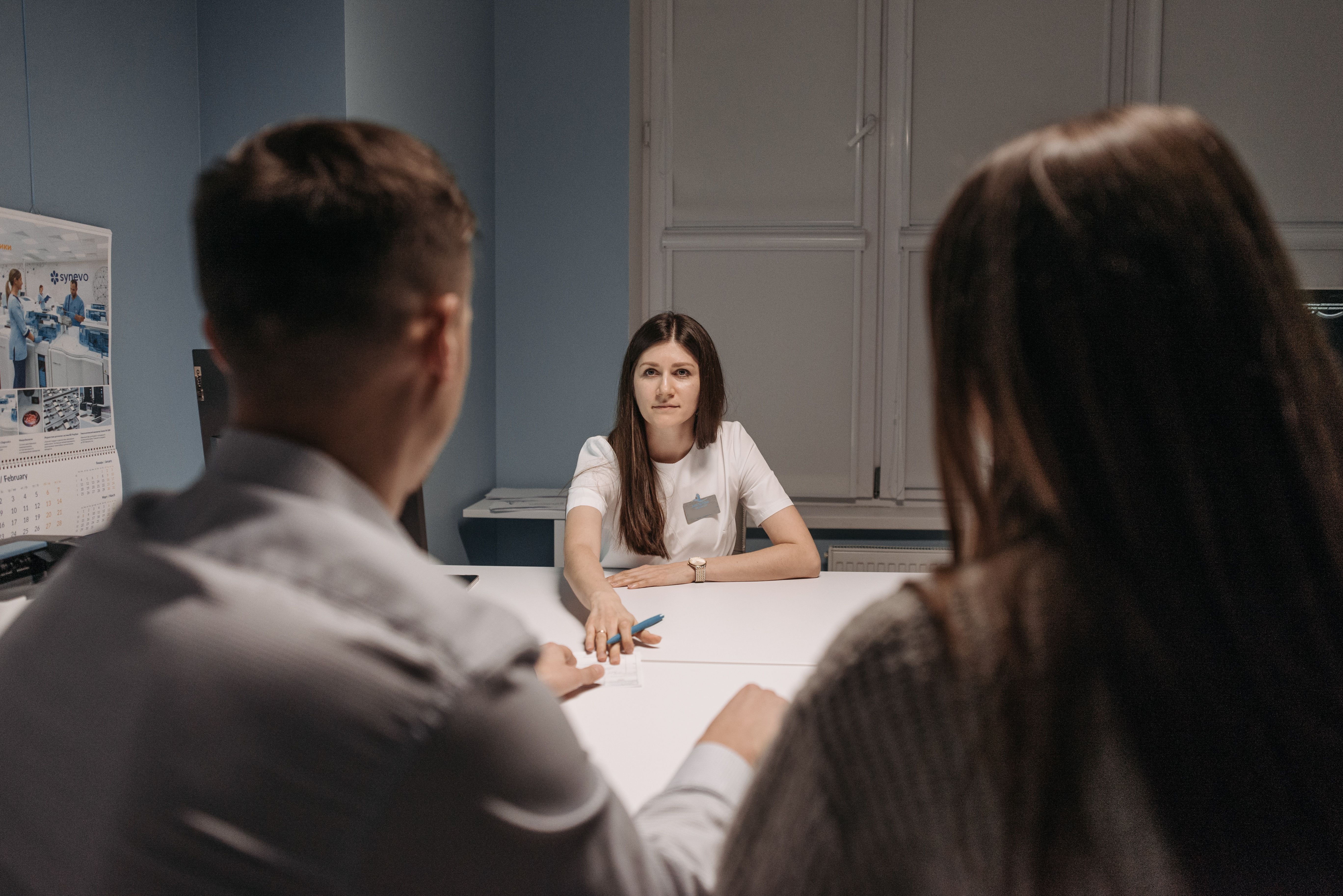 Healthcare professional speaking with a patient at a desk